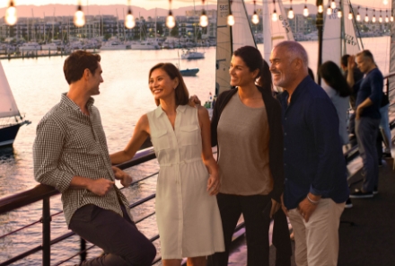 Los Angeles boat party with four people on top deck of yacht with sailboats in the background