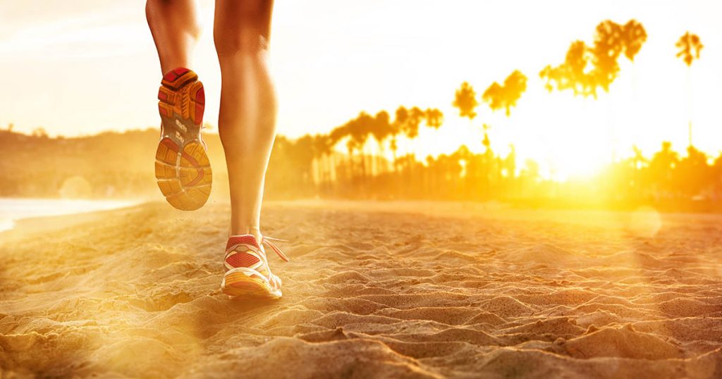 person running on beach close up of shoes