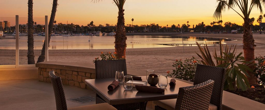 outdoor dining area at dusk with marina in background