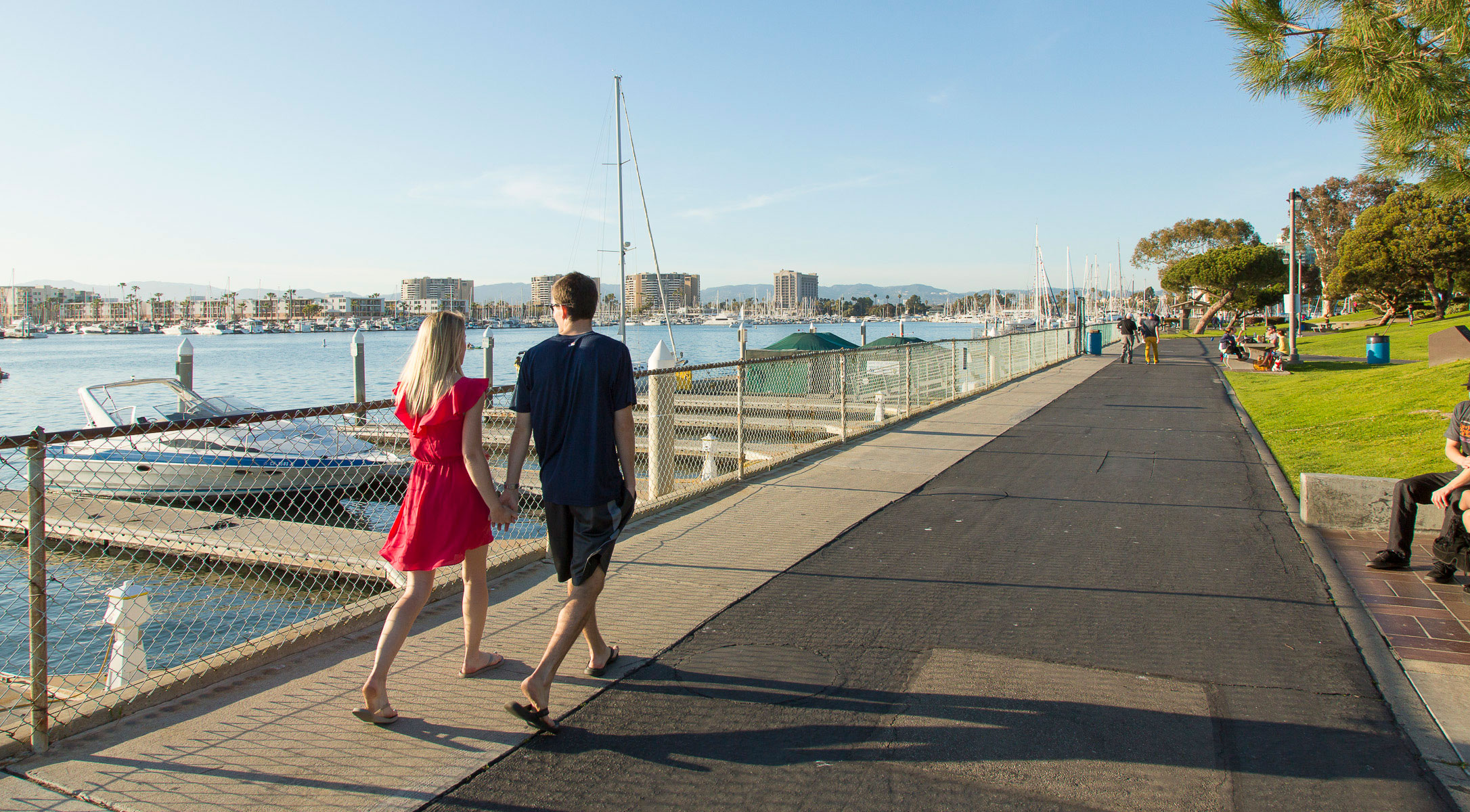 couple strolling in park along marina