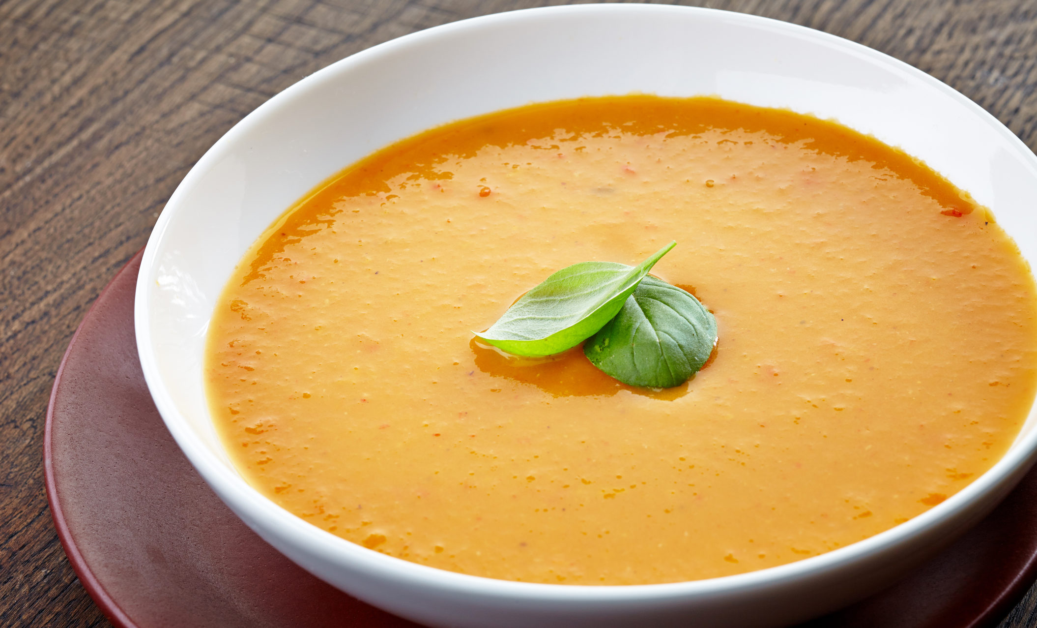 bowl of butternut squash soup with basil garnish