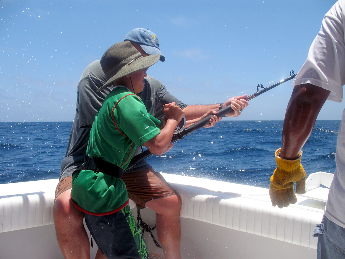 dad teaching young boy how to fish