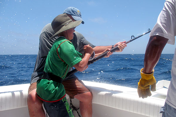 Guys fishing off the side of boat