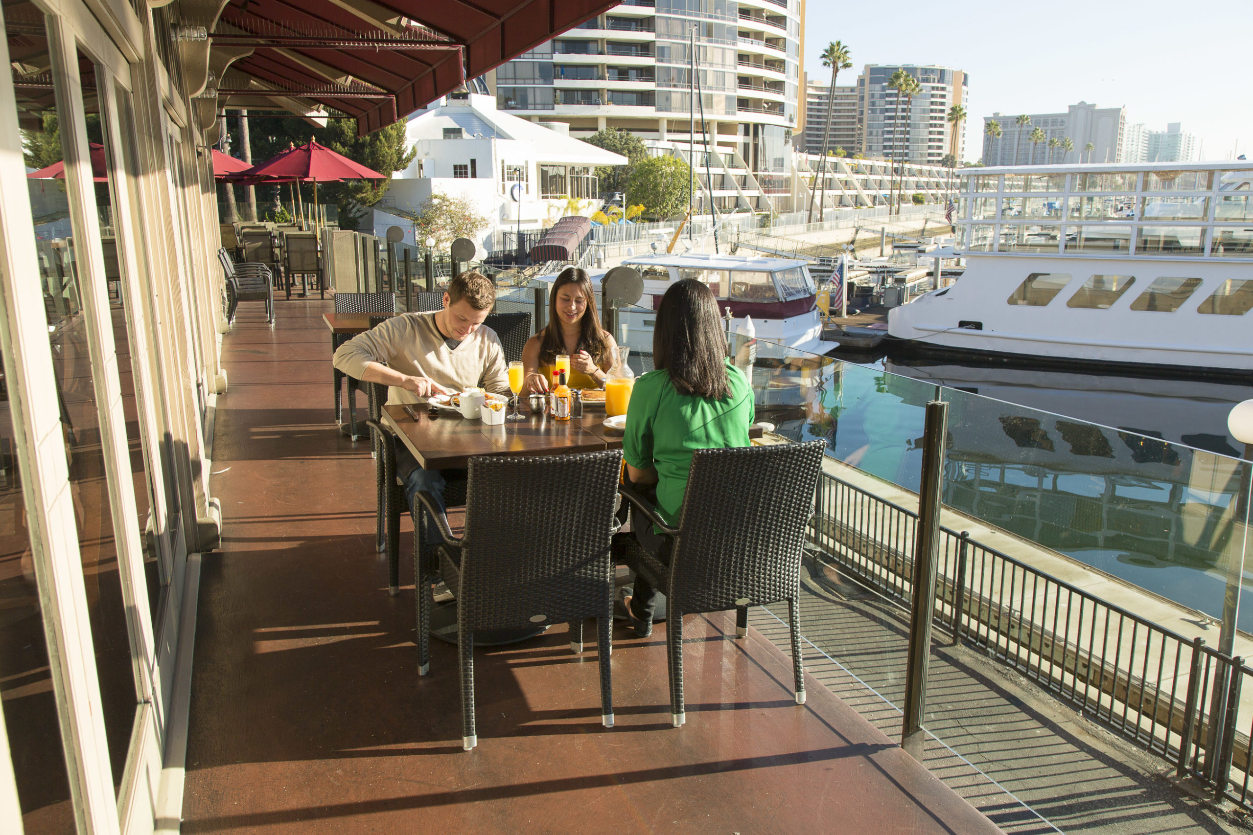 people eating on patio facing harbor and boats