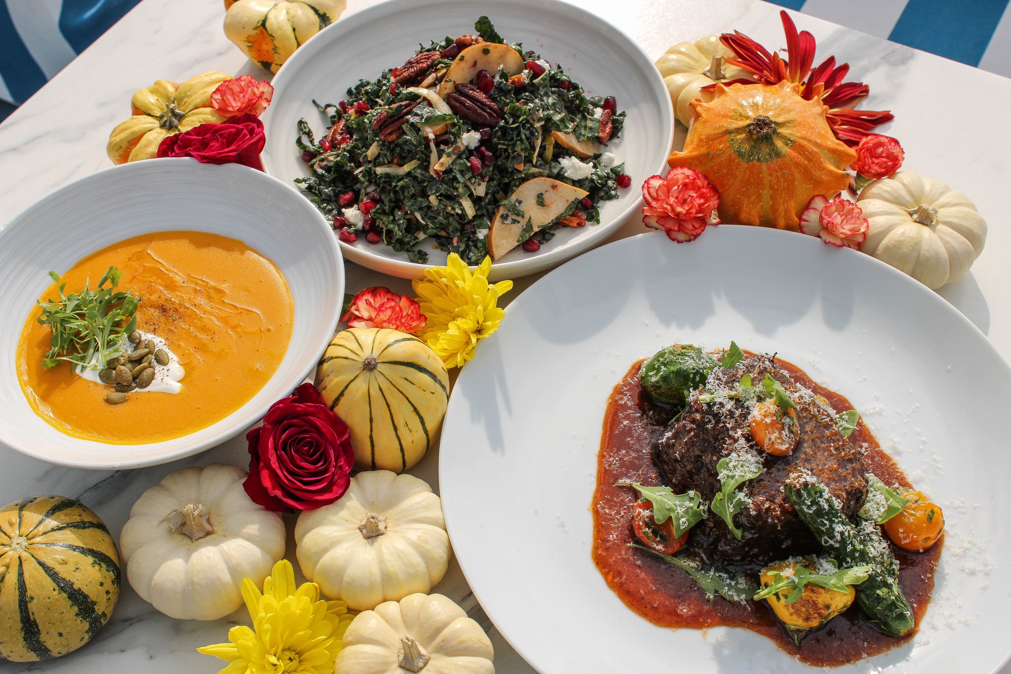 bowls and dishes of salad and pumpkin soup for Thanksgiving dinner