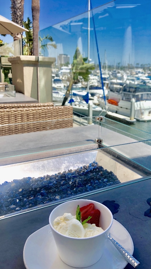 Ice cream on patio table facing harbor with boats