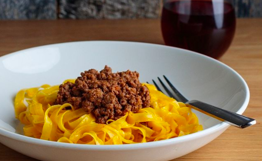 bowl of pasta with ragu and a fork